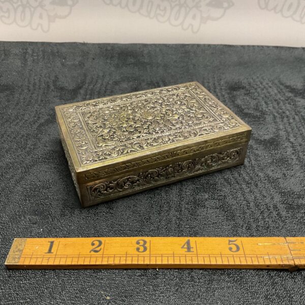Intricate antique Persian trinket box with embossed floral designs.