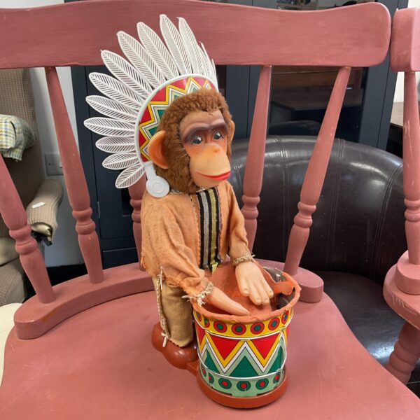 Side view of vintage Japanese drumming monkey toy.