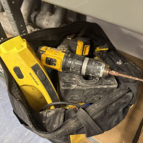 Black tool bag containing a Dewalt cordless drill.