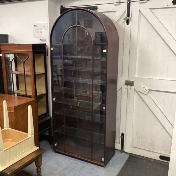 Vintage wall display cabinet with curved glass panels.