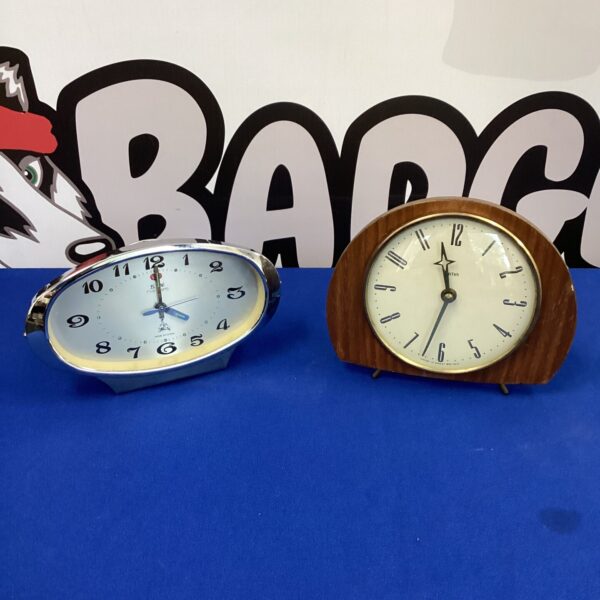 Vintage mantle clock pair, including a Smiths clock, in used condition.