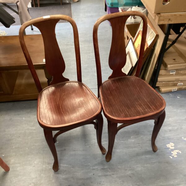 Pair of vintage bentwood dining chairs with curved backs.