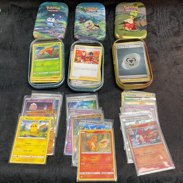 Lot of three Pokemon card tins for collectors.