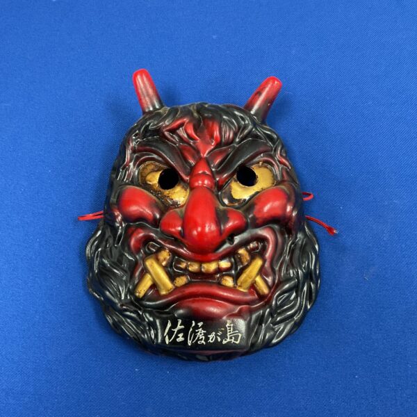 Detailed Japanese Oni mask crafted from dark ceramic pottery.