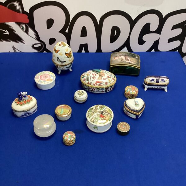 Selection of colourful porcelain trinket boxes on a blue background.