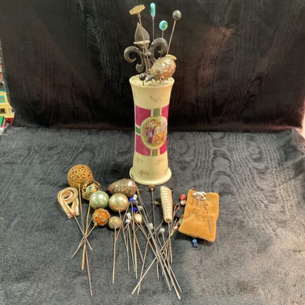 Vintage hat pin collection on a decorative porcelain stand.