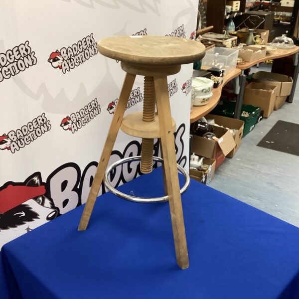 Vintage adjustable wooden stool with rustic charm.