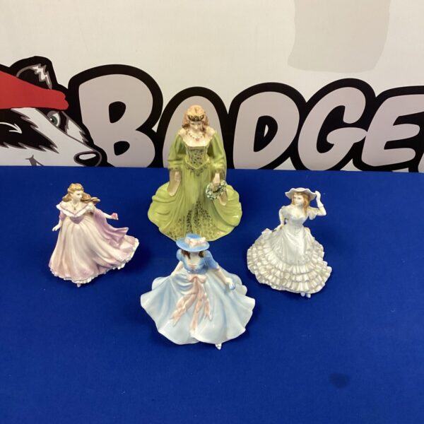 Lot of four vintage Royal Doulton lady figurines on display.