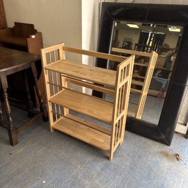 Light oak shoe rack with three tiers for shoe storage.