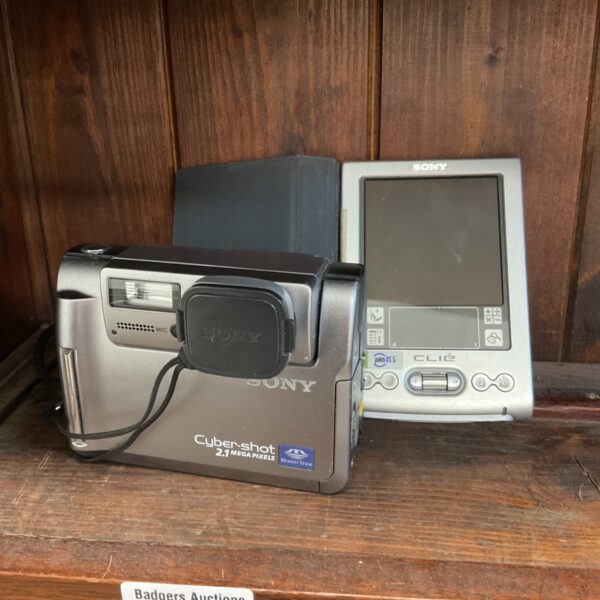 Vintage Sony DSC-F55 camera and CLIE palm organizer, retro digital tech.