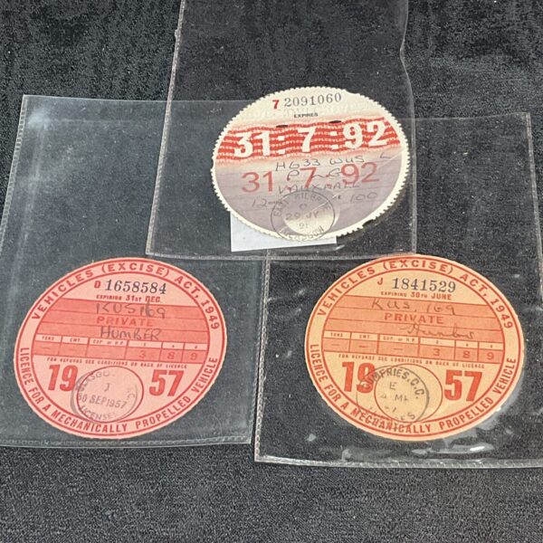 Lot of three vintage car tax discs, collectible automotive memorabilia.
