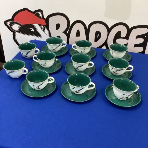 Lot of vintage Denby Greenwheat cups and saucers on display.