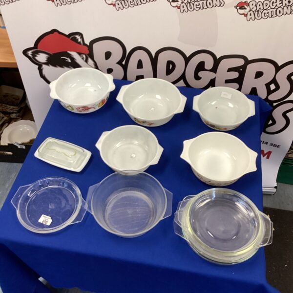 Vintage Pyrex dishes with clear glass lids for kitchen storage.