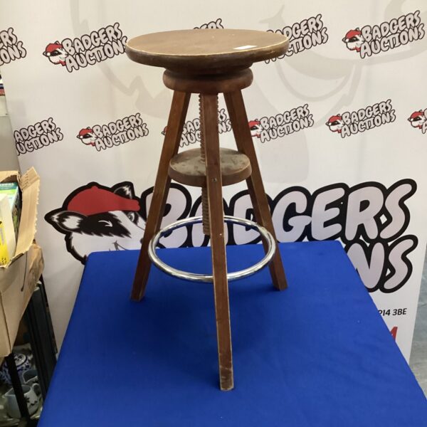 Vintage wooden adjustable stool with circular seat and tripod base.