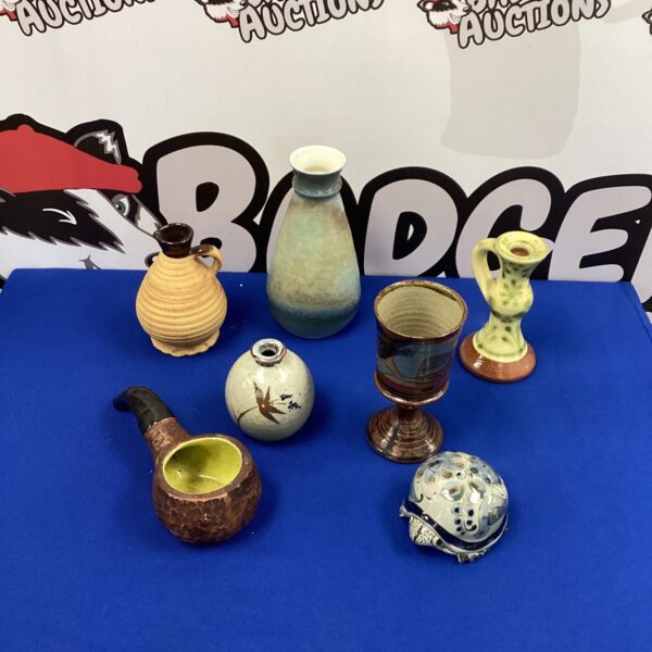 Handmade pottery collection featuring glazed vases and a decorative pipe.