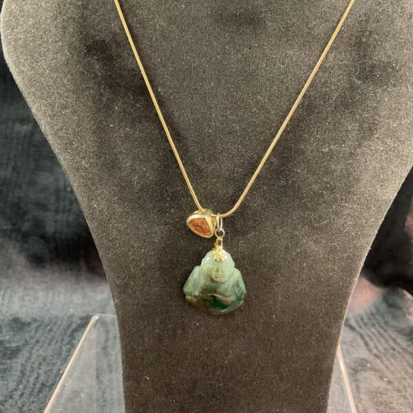 Vintage jade Buddha pendant necklace with orange sapphire detail.