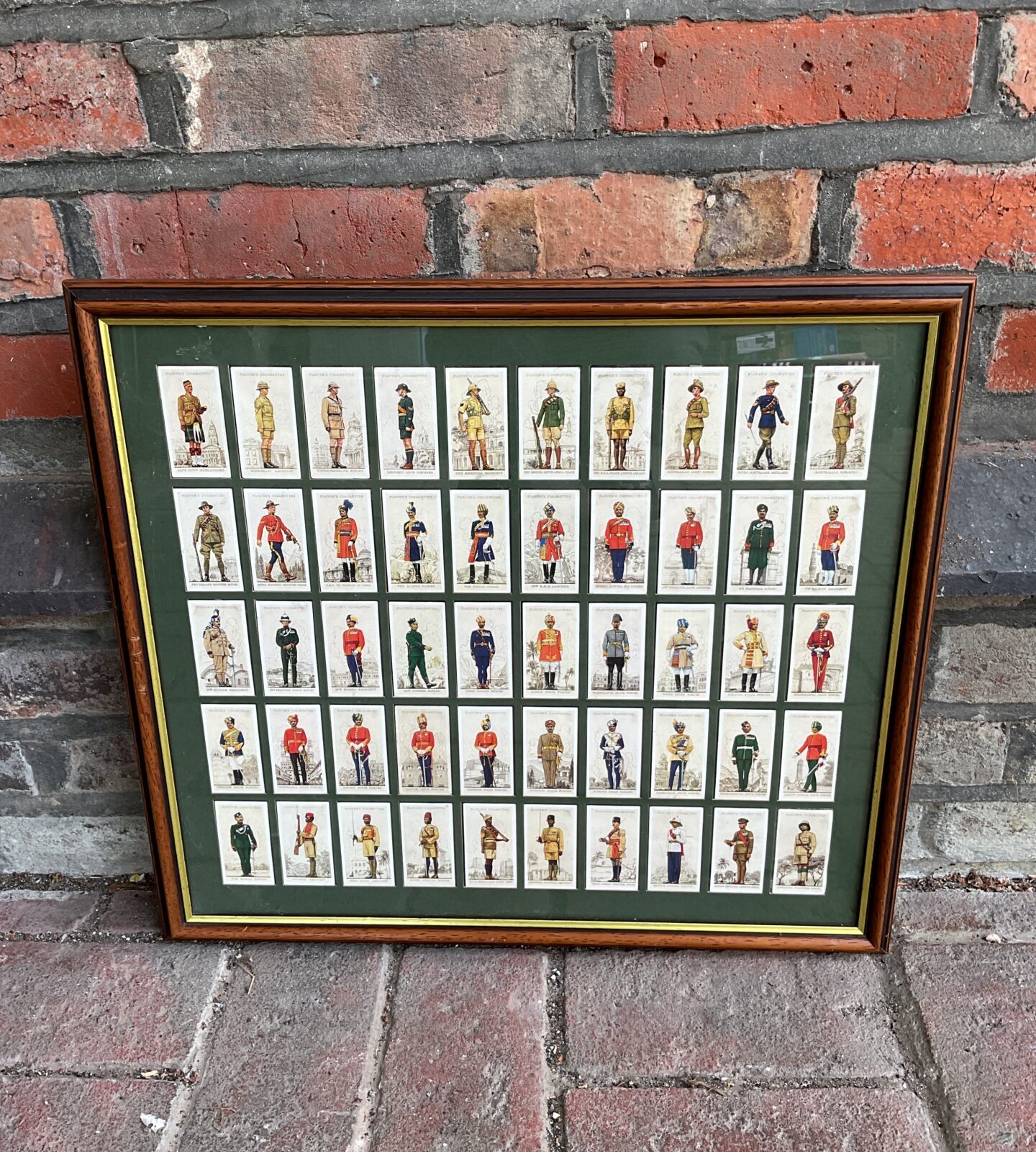 Framed set of vintage players military uniforms cigarette cards