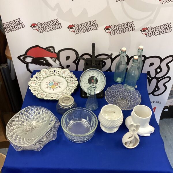 Vintage mixed lot of bottles, ceramics and glassware on display.