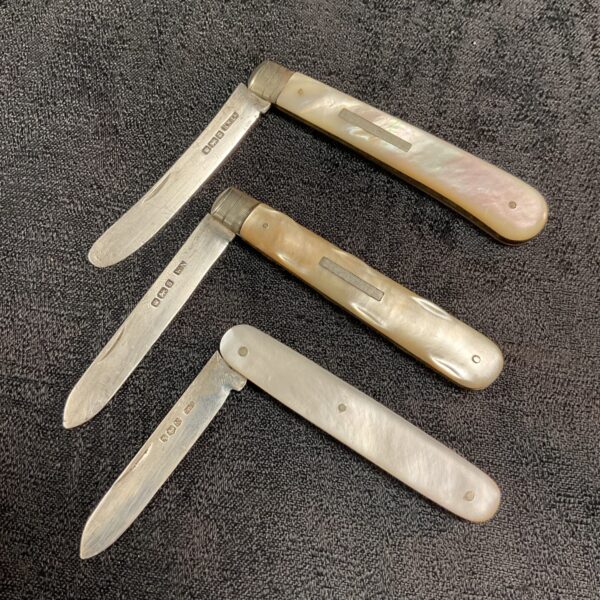Antique silver fruit knives with mother of pearl handles.