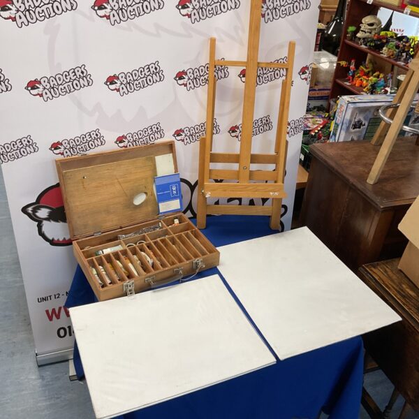 Wooden artist easel with open case of painting supplies.