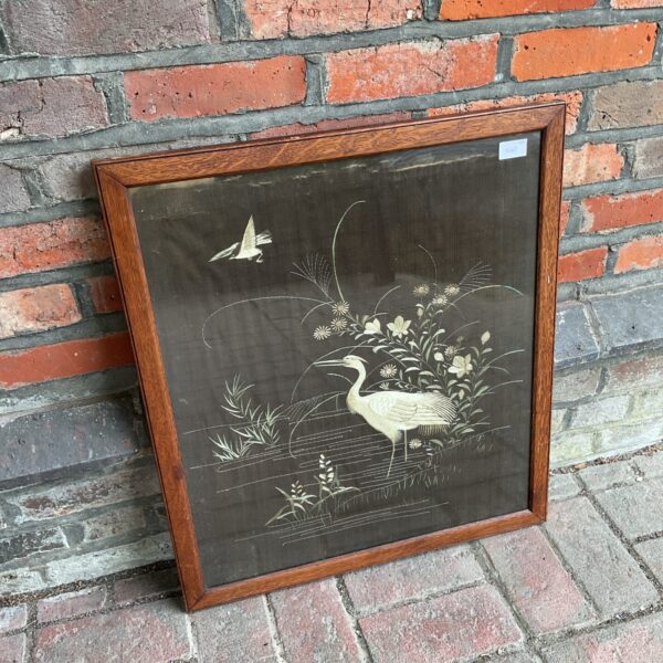 Vintage oriental silk embroidery featuring crane birds in an oak frame.