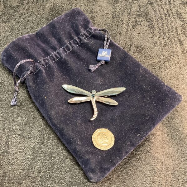 Close-up of a sparkling Swarovski crystal dragonfly brooch.