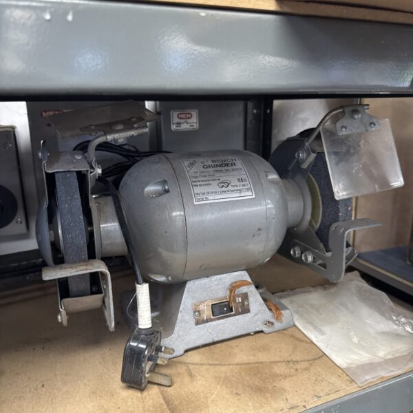Close-up of a Hilka bench grinder in a workshop setting.