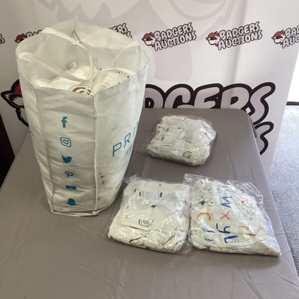 Lot of new baby starter kits with bibs and changing mats.