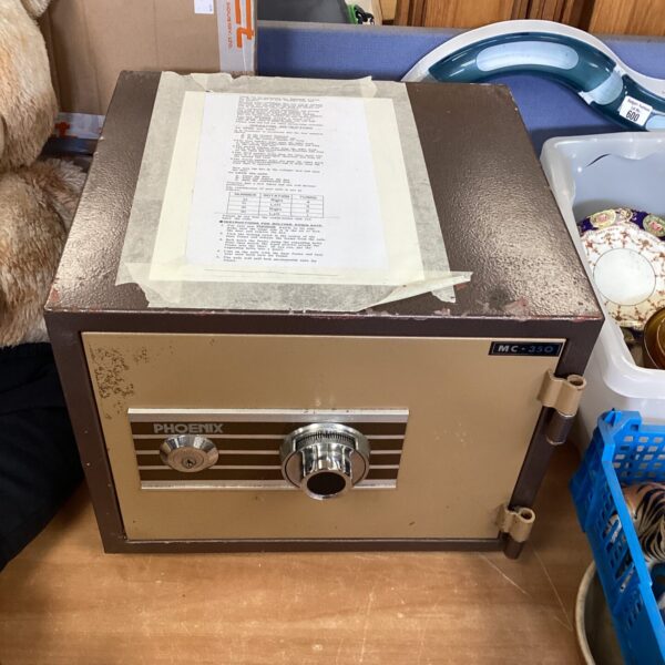 Front view of a vintage Phoenix safe with key and dial.