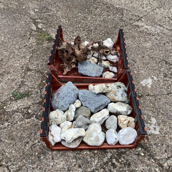 Tray of natural garden stones and driftwood for landscaping.