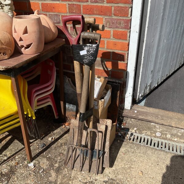 Bundle of garden tools including shovels and forks for gardening.