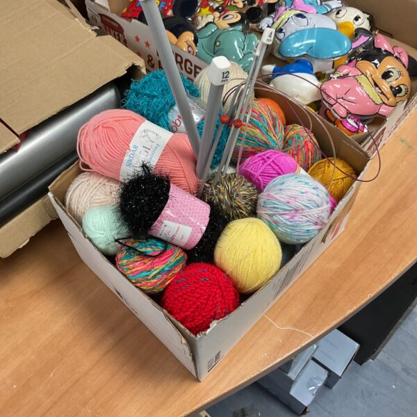 Colourful knitting yarn lot with various textures and shades.