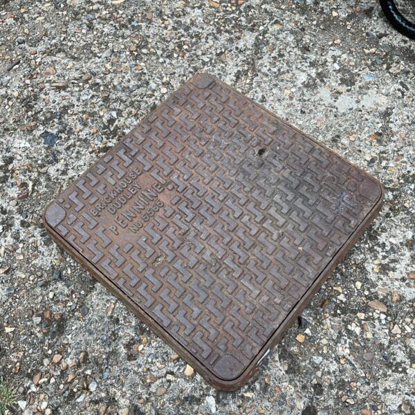 Vintage Brick House Dudley Pennine manhole cover with textured surface.