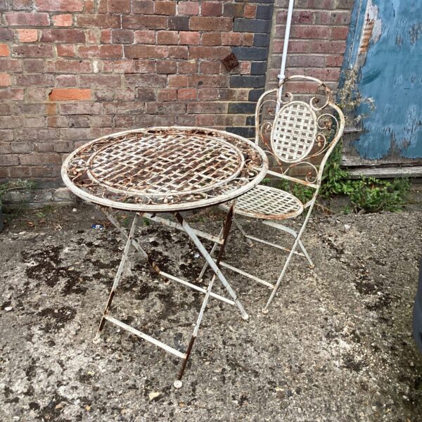 Rusted vintage metal garden furniture set with floral detailing.