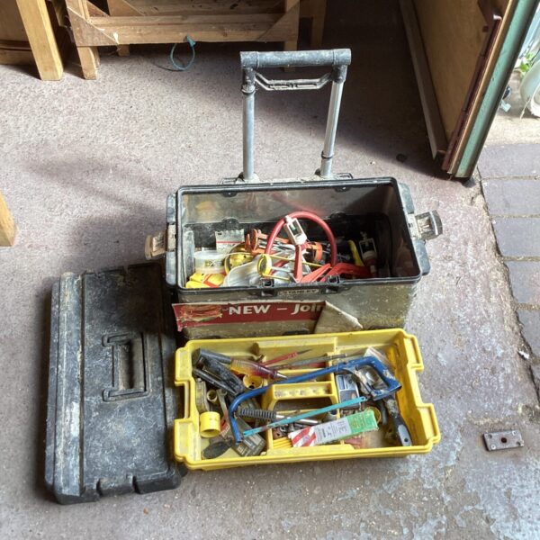 Vintage Stanley tool box filled with various tools and hardware.