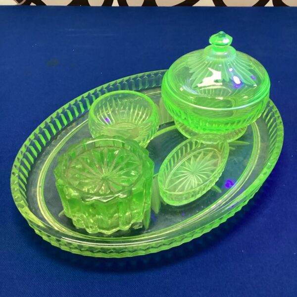 Antique uranium glass dressing table set with green powder box and mirror.