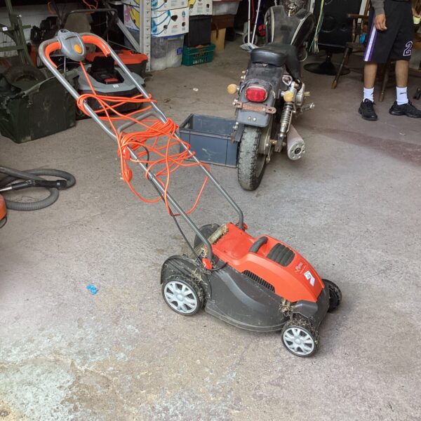 Used Flymo electric mower in a garden setting.