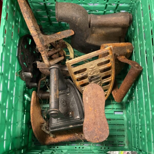 Crate of antique irons trivets and shoe last