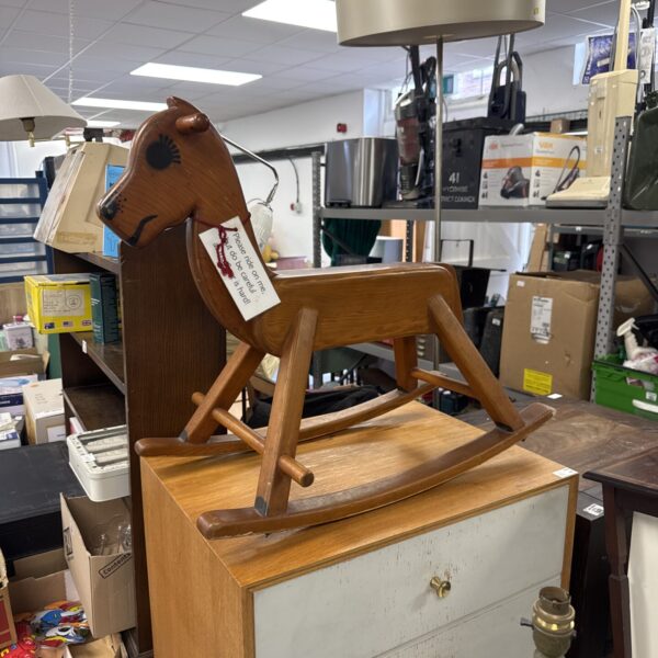 Vintage 1985 wooden rocking horse in natural light.
