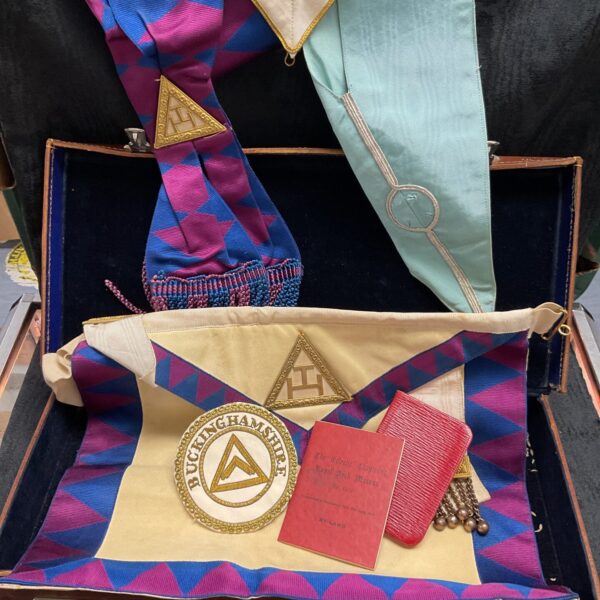 Open antique leather case displaying Masonic collars and apron.