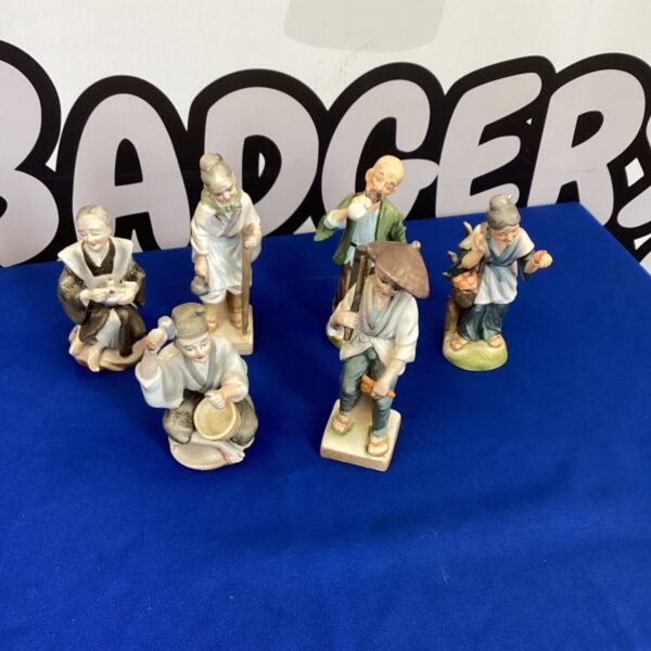 Vintage Japanese figurines depicting traditional scenes and characters.