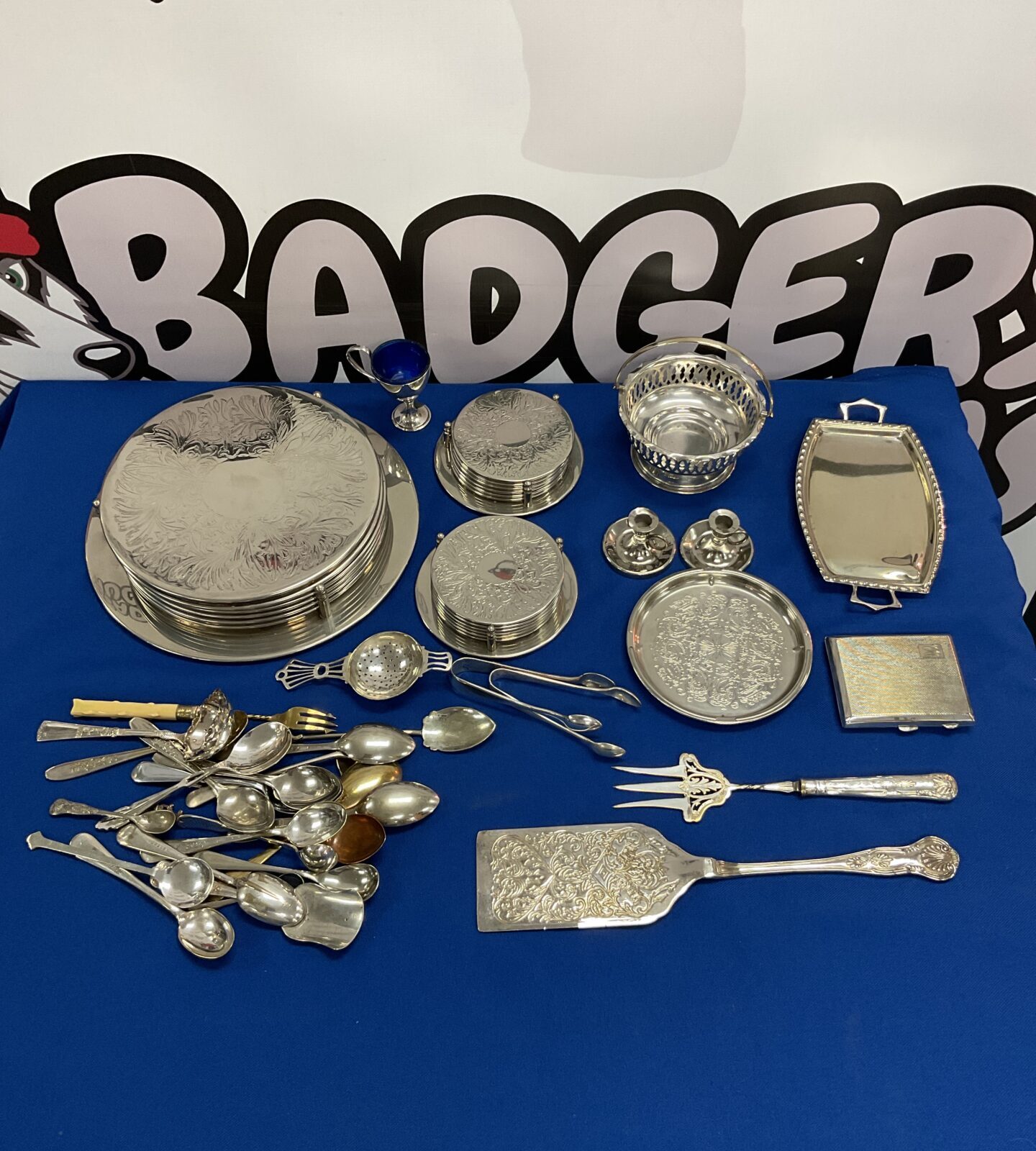 Box of silver plate coasters, cutlery & candlesticks