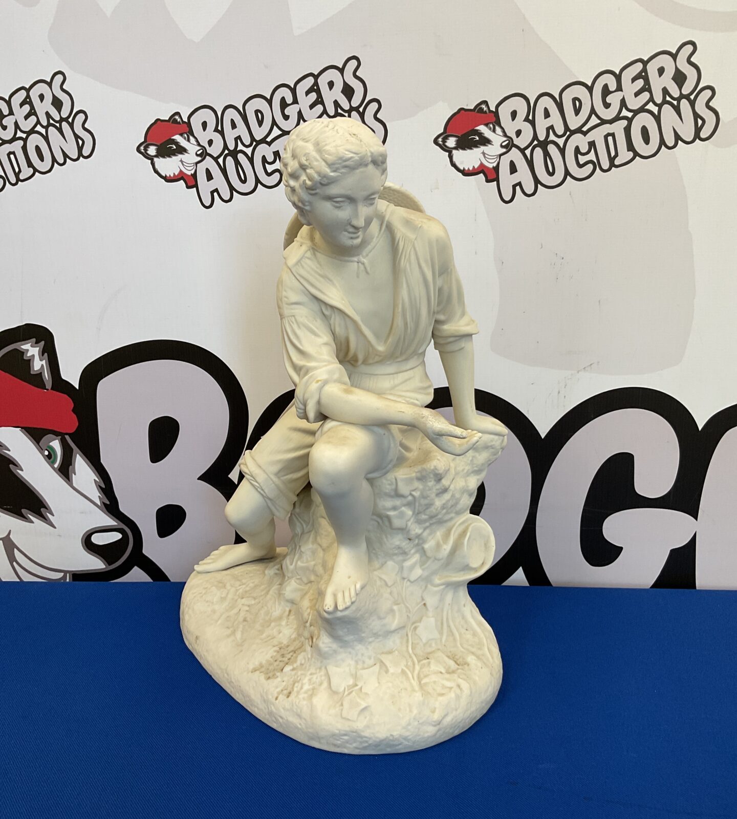 Parian ware figure of a young man sitting on stump