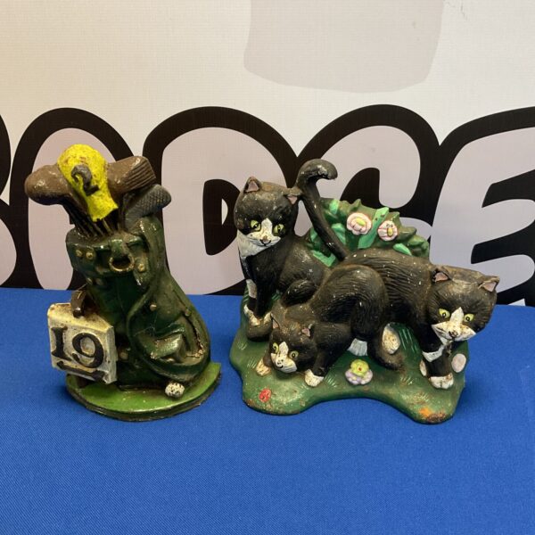 Antique cast iron doorstops featuring a black cat and golf bag.
