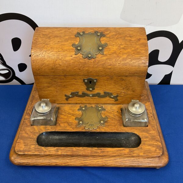 Vintage oak pen stand with two inkwells on a white background.