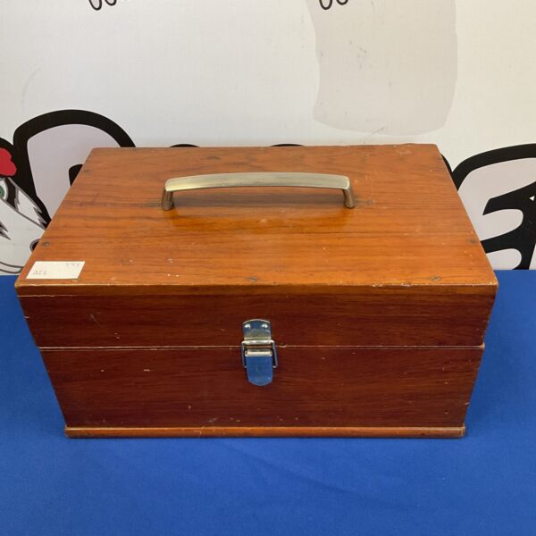 Front view of a vintage wooden box with handle.