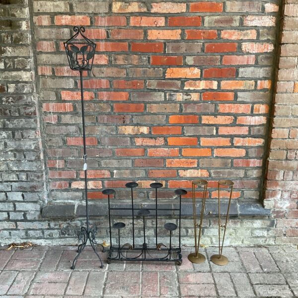 Four large vintage iron candle stands with tiered designs for warm lighting.