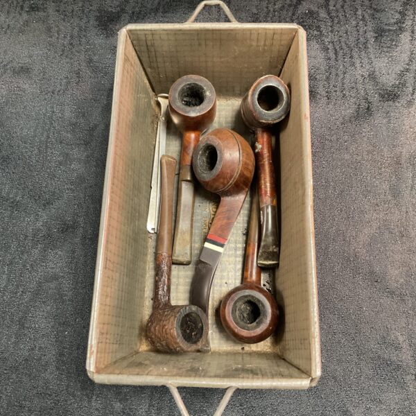 Vintage smoking pipes displayed in a tray, collectible pipe lot.
