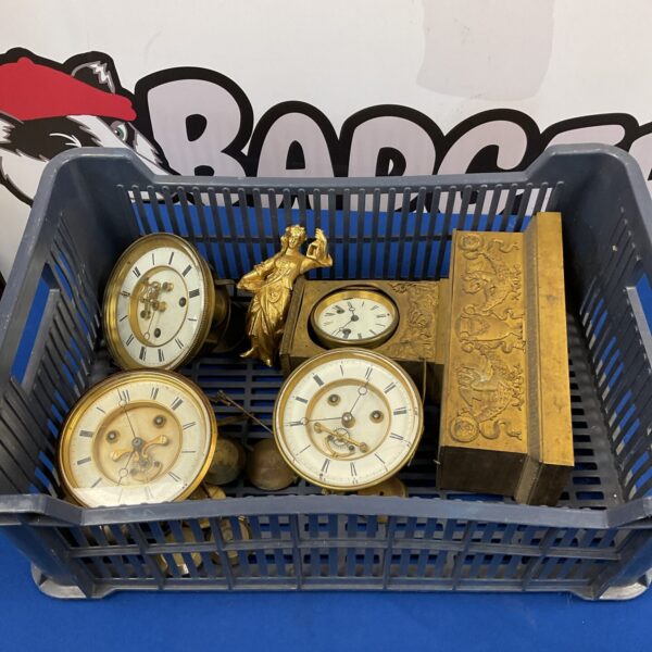 Vintage clock parts lot with gears, springs, and dials.