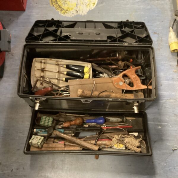 Open vintage metal tool box filled with hand tools.